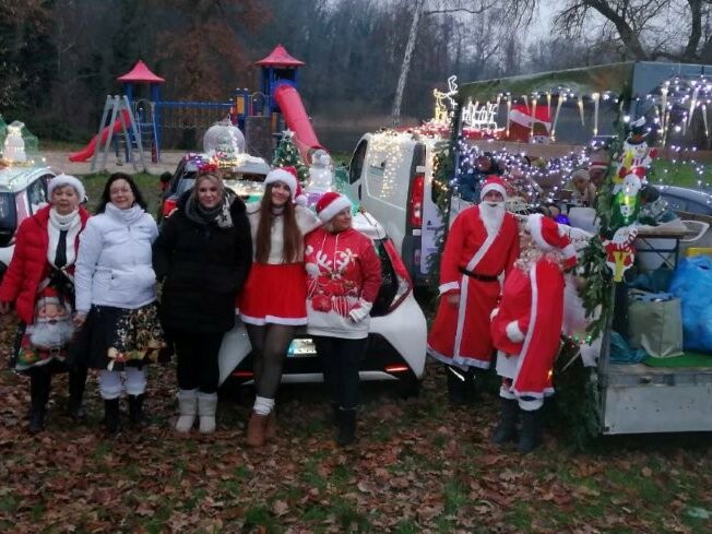 Gruppenfoto vor den weihnachtlichen geschmückten Autos