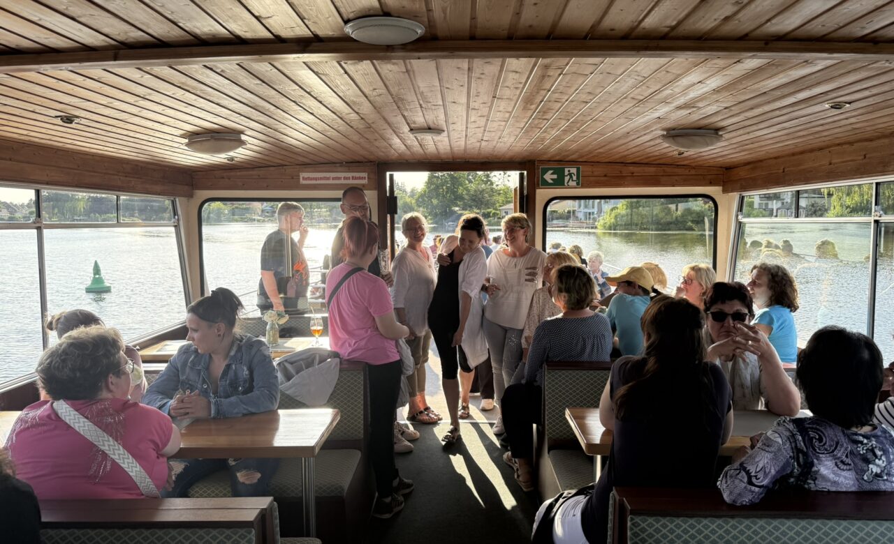 Personen auf dem Boot am sitzen am Tisch. Einige stehen.