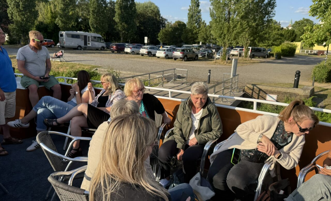 Personen auf dem Boot am sitzen am Tisch und einige stehen.